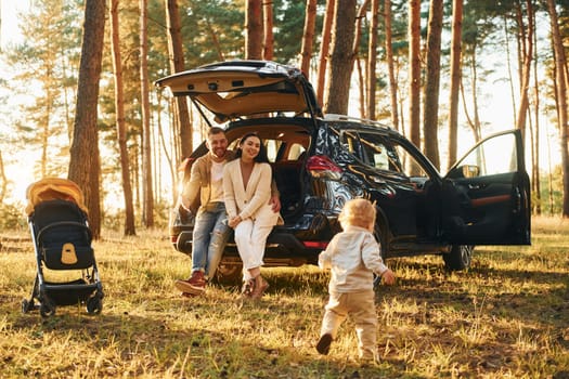 Joy and happiness. Family of father, mother and little daughter is in the forest.