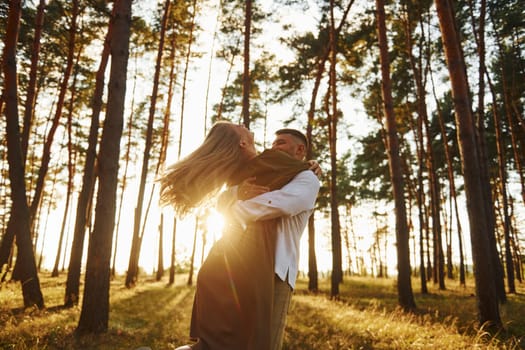 Weekend time spending. Happy couple is outdoors in the forest at daytime.