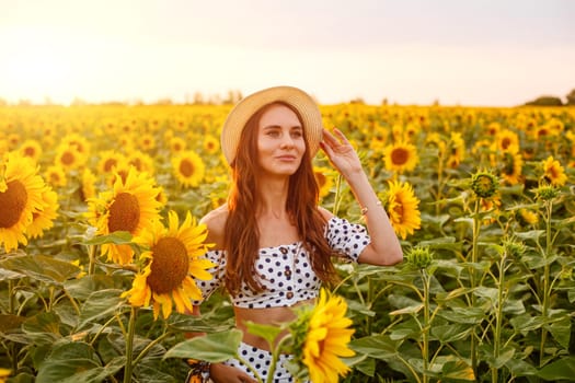 Portrait of young cute woman in straw hat . Outdoors on the sunflower field. Caucasian girl in casual clothes at sunset enjoying the evening in a field of bright sunflowers