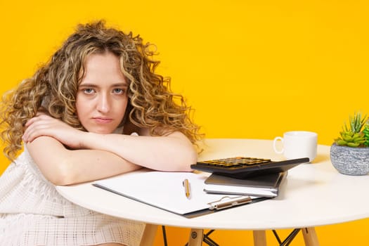 Young woman is sitting at the table, tired of office work. Education. Business.