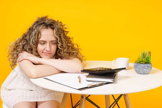 Young woman is sitting at the table, tired of office work. Education. Business.