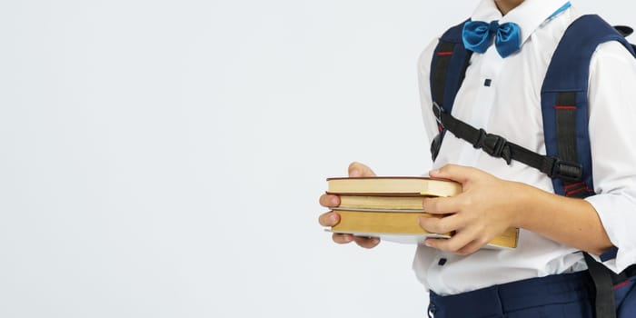 Pupil holding books in hands, isolated background. Education concept