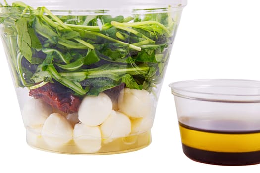 Fresh salad with arugula, mozzarella cheese, sun-dried tomato on a white background. Side view. Isolate.