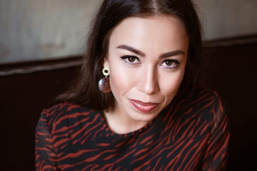 Female beautiful portrait of a brunette Caucasian nationality close-up, beautiful brown eyes with makeup in a young woman