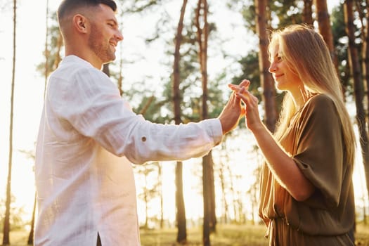 Cheerful people. Happy couple is outdoors in the forest at daytime.