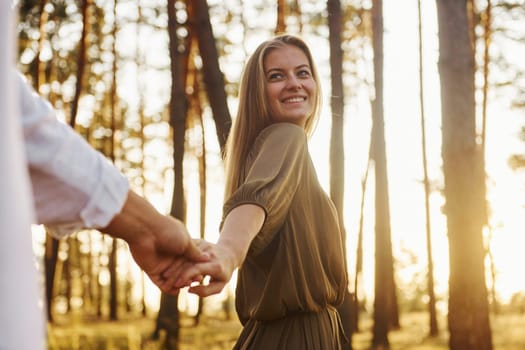 Non urban scene. Happy couple is outdoors in the forest at daytime.