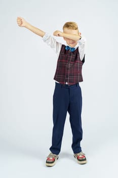 A portrait of a schoolboy who raised his hands up and makes a gesture with his hands. Isolated background. Education concept.