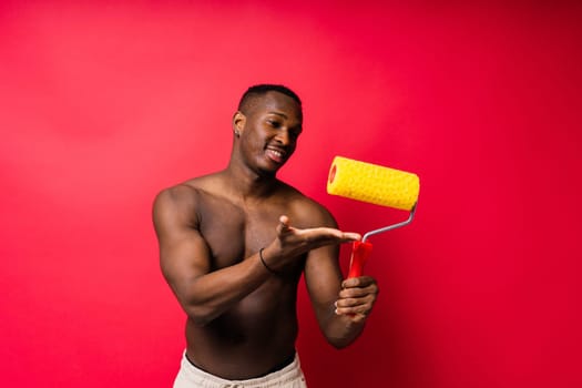 African-American painter on a red studio background topless