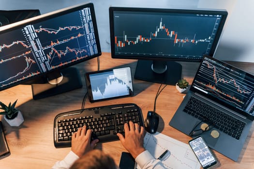 International business. Young man in formal clothes is in office with multiple screens.