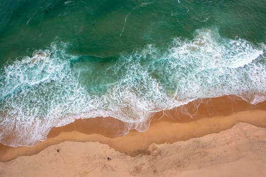 Beautiful tropical sandy empty beach and sea waves seen from above. Atlantic ocean beach aerial view
