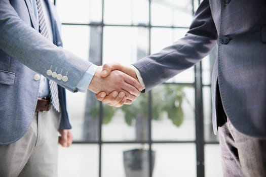 businessman standing greeting partner with handshake. Leadership, trust, partnership concept.