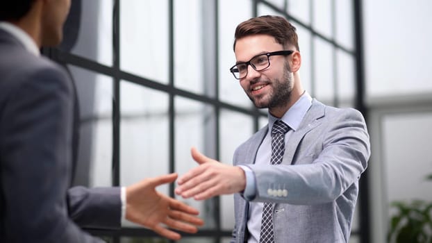 Happy businessmen greeting each other in the office.