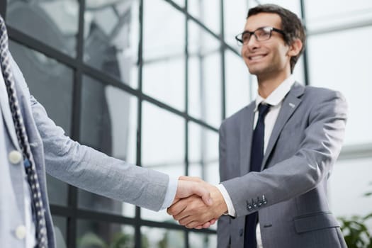 Delighted businessmen shaking hands, greeting acquaintance in the office,
