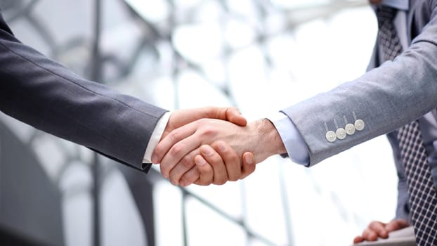 Happy businessmen greeting each other in the office.