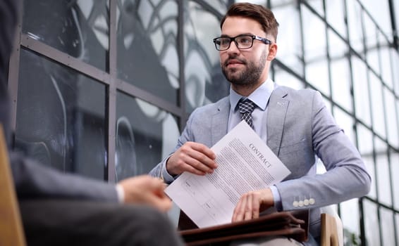 Businessman signing contract on the meeting while sitting in the office