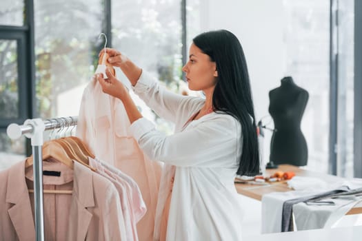 Taking clothes. Seamstress is in her office at daytime.
