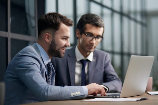 Two man colleagues working at the office on a computer