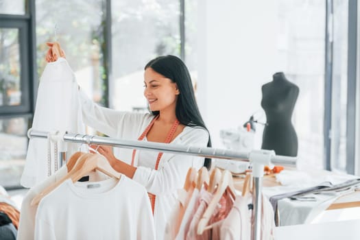 Taking clothes. Seamstress is in her office at daytime.