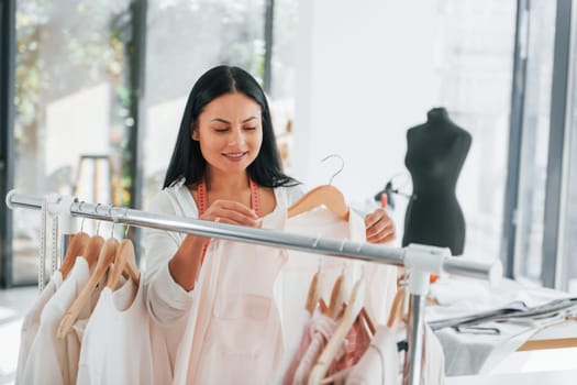 Looking for shirt. Seamstress is in her office that is with different clothes.