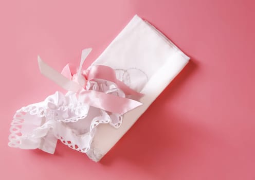 The bride's garter on a pink background. Wedding dress detail.