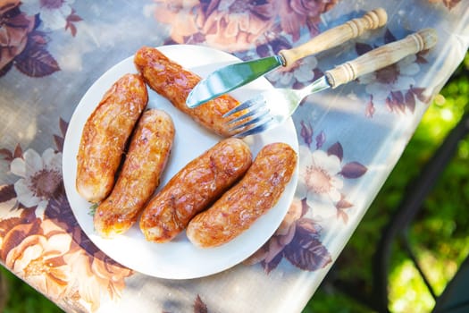 Grilled Bavarian sausages, delicious spit sausages. Shish kebab with sausages on a plate. Outdoor recreation