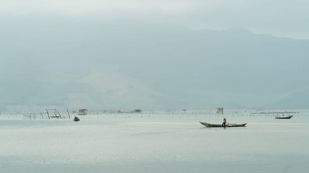Fishing on a boat on a foggy morning against the backdrop of mountains. High quality photo