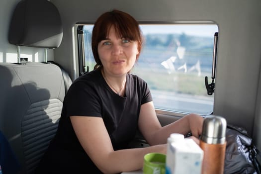beautiful Happy woman looking at camera from her camper van