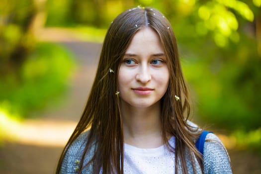 Female portrait of a young woman of Caucasian appearance stit in the park on a path in a spring day