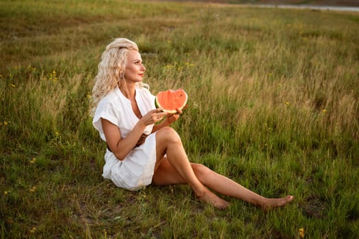 Portrait of a happy young woman enjoying and eating watermelon outdoors, slow life. Summer lifestyle concept. Happiness, joy, holiday independence day.