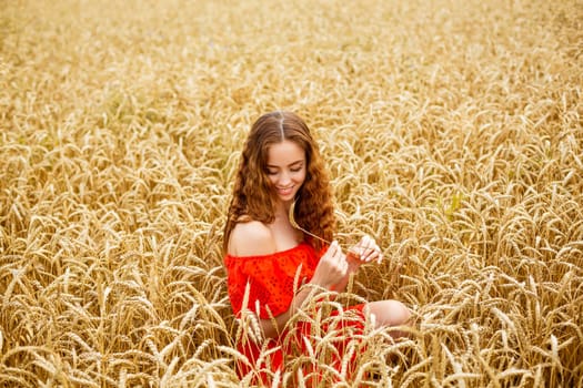 Style redhead young woman in red clothe on wheat nature Happy girl with curly hair in field. Sweet smile on face of lovely free girl. Caucasian real girl. Happy woman enjoying freedom.