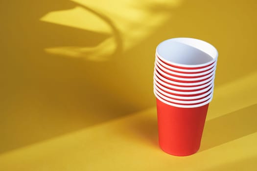 red paper coffee cups on a yellow background are the morning concept of disposable tableware