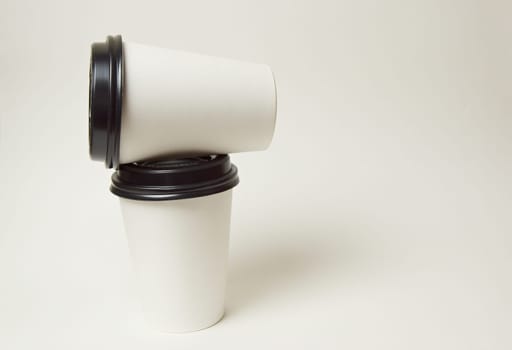 Paper coffee container with black lid and coffee beans on a white background white coffee paper cup with black lid takeaway coffee