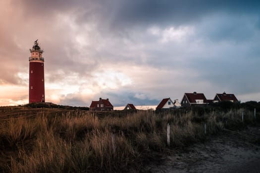 Red lighthouse at the little isle of Texel, the Netherlands with small small old red h and white houses