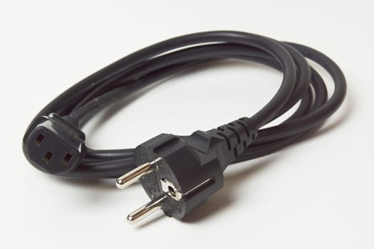 the voltage cable for the TV is a black electrical plug with a cable isolated on a white background