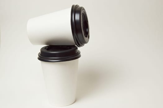 Paper coffee container with black lid and coffee beans on a white background white coffee paper cup with black lid takeaway coffee