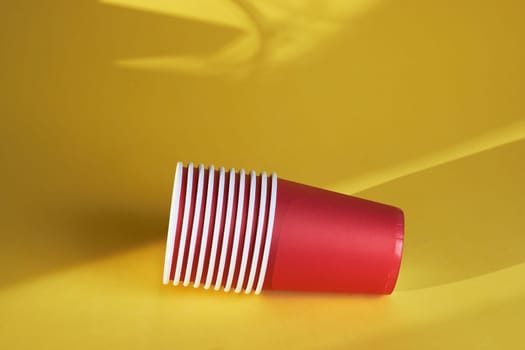 red paper coffee cups on a yellow background are the morning concept of disposable tableware