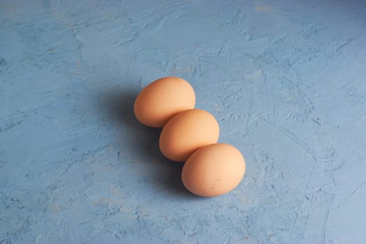 Three red Easter eggs on a blue background. Colorful decoration of Easter eggs. Flat position, top view. with a place to copy the text. Minimal idea for an Easter concept.