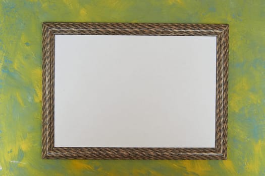 wooden brown photo frame with a white monochrome photo on an abstract yellow-green background