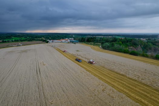 View from above on the harvesters harvesting wheat and the countryside. Wheat harvest. Work of harvesters in the field.