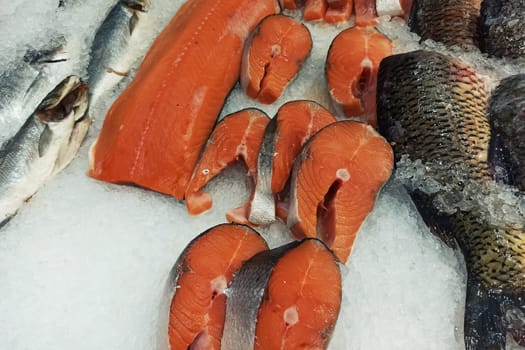 Fillet of red fish on ice in the showcase close up