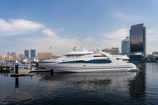 View across the Creek towards Deira with large boats docked in Dubai, UAE