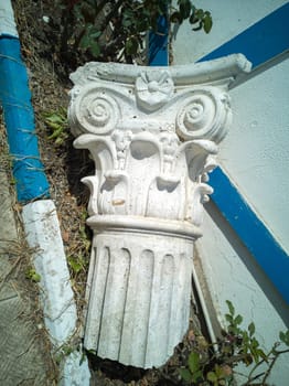 Capital, crowning part of an ancient antique column or pilaster, lying on the street