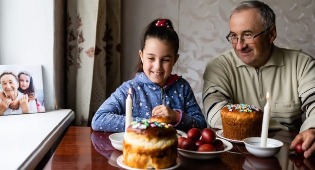 Family Decorating Easter Eggs On Table, grandfather and granddaughter