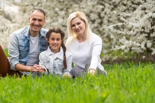 Family and small child outdoors in spring nature, resting