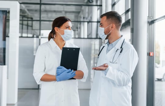 Having busy day. Two doctors in white coats is in the clinic working together.