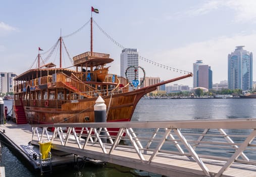 Dubai, UAE - 31 March 2023: Largest dhow cruise boat docked in the Creek by Bur Dubai souk