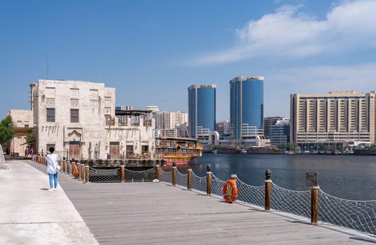 Dubai, UAE - 31 March 2023: View along the Creek towards Deira with large dhow tour boats docked by the Al Seef boardwalk