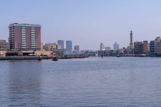 Dubai, UAE - 31 March 2023: The Creek from Bur Dubai to Deira with traditional Abra docked on the waterfront