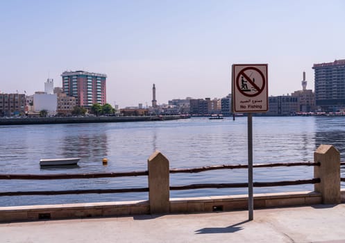 Dubai, UAE - 31 March 2023: The Creek from Bur Dubai to Deira with no fishing sign on the waterfront