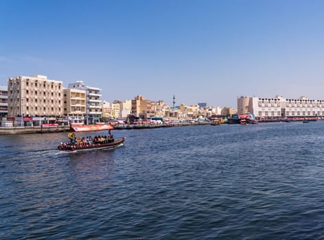 Dubai, UAE - 31 March 2023: Tourists crossing the Creek from Bur Dubai to Deira on a traditional Abra